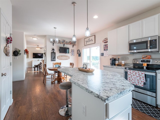 kitchen with white cabinetry, appliances with stainless steel finishes, dark wood-type flooring, and a kitchen island