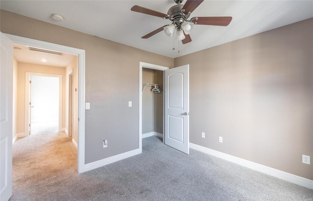 unfurnished bedroom featuring ceiling fan, light carpet, and a closet