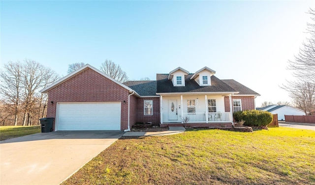 cape cod-style house with covered porch, a front yard, and a garage