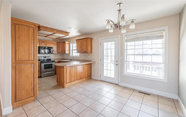 kitchen with kitchen peninsula, sink, decorative light fixtures, a chandelier, and stainless steel range with electric cooktop