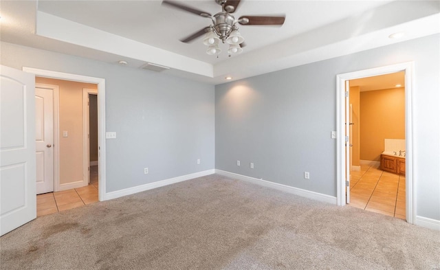 unfurnished bedroom featuring light carpet, ensuite bath, and ceiling fan