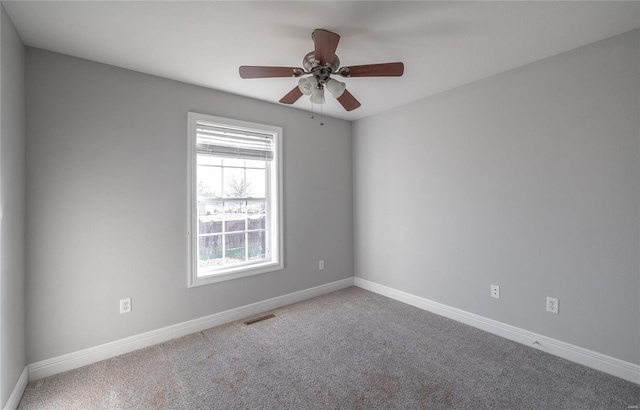 spare room featuring ceiling fan and carpet floors