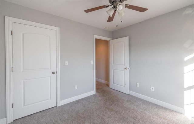 unfurnished bedroom with ceiling fan and light colored carpet