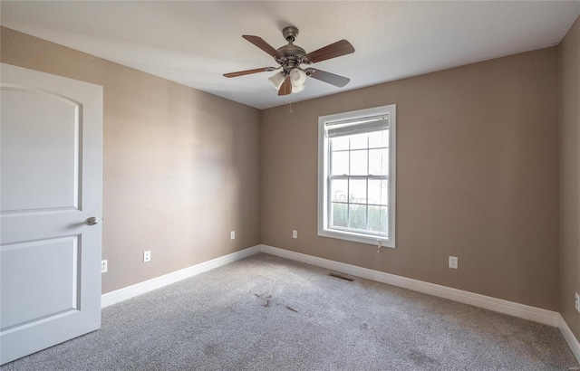 unfurnished room with light colored carpet and ceiling fan