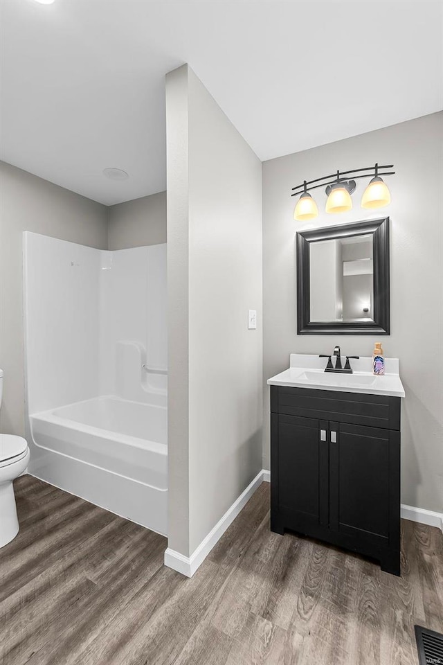 full bathroom featuring bathtub / shower combination, hardwood / wood-style floors, toilet, and vanity