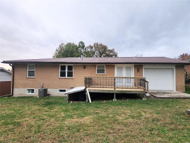 back of house featuring a lawn, central AC, a wooden deck, and a garage