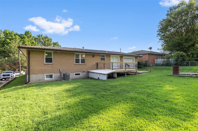 back of house featuring a wooden deck, cooling unit, and a lawn