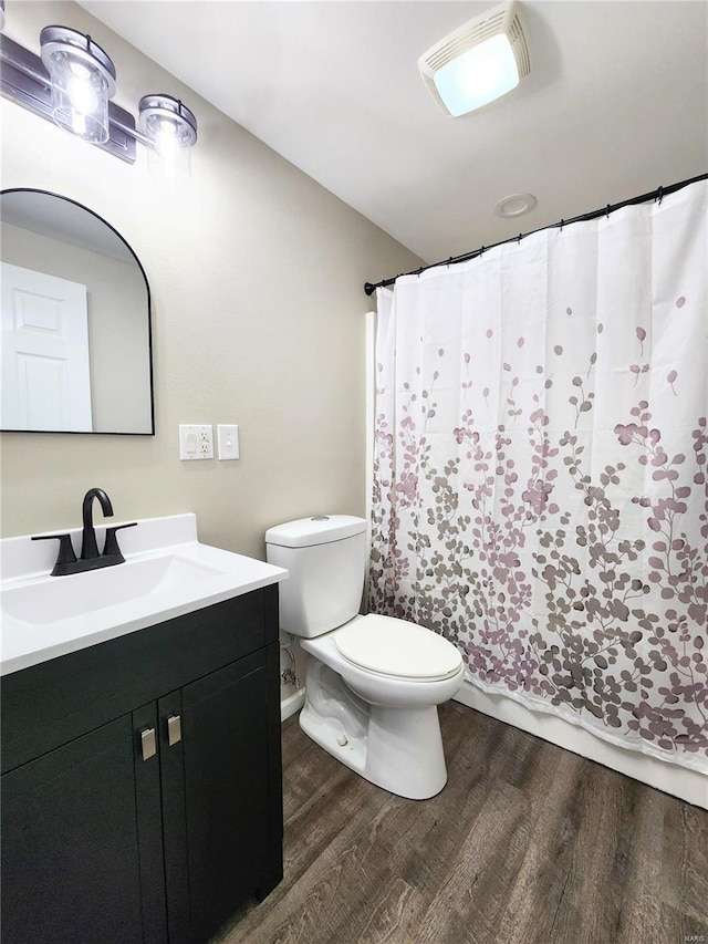 bathroom featuring toilet, wood-type flooring, and vanity