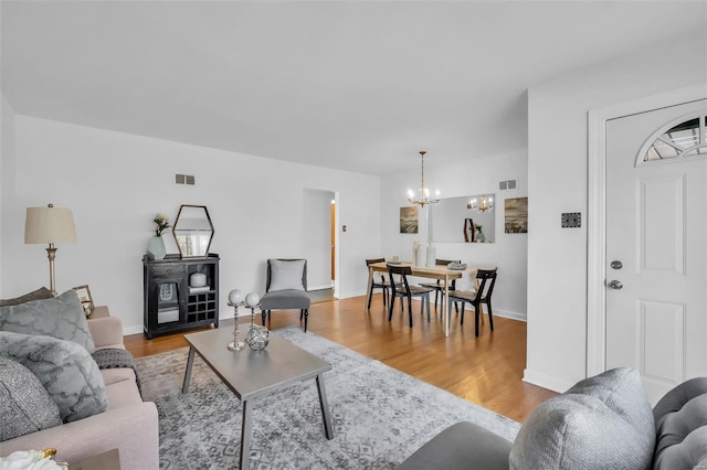 living room featuring a chandelier and light hardwood / wood-style flooring