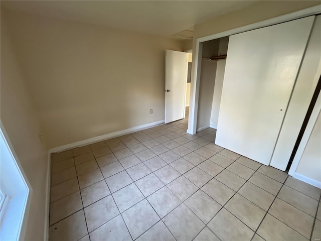 unfurnished bedroom with light tile patterned floors and a closet