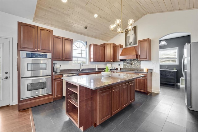 kitchen featuring pendant lighting, appliances with stainless steel finishes, a kitchen island, wooden ceiling, and premium range hood