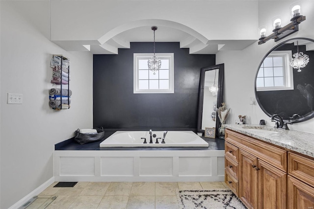 bathroom featuring a bathing tub, vanity, a chandelier, tile patterned flooring, and baseboards