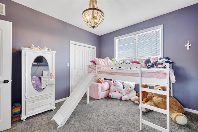 carpeted bedroom with an inviting chandelier, baseboards, visible vents, and a closet