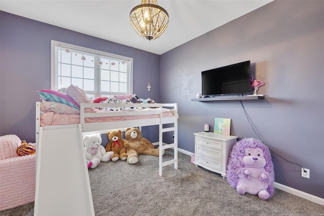 carpeted bedroom with a chandelier and baseboards