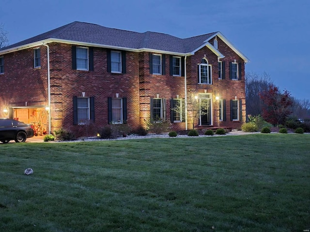 colonial house featuring a yard and a garage