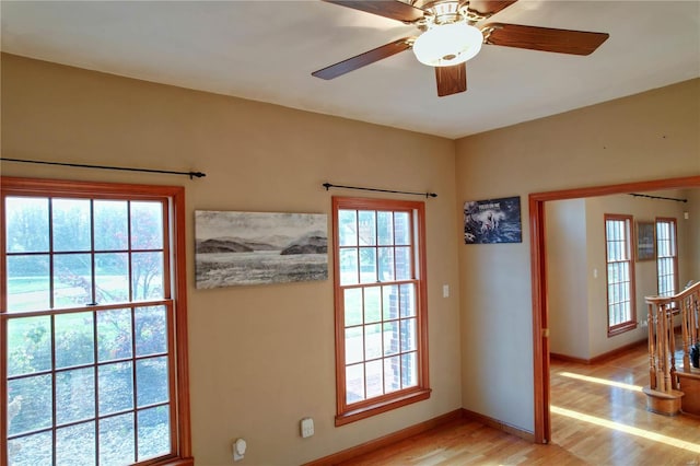 doorway with ceiling fan, a wealth of natural light, and light hardwood / wood-style floors