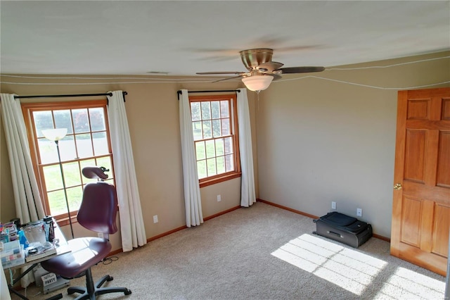 unfurnished office with ceiling fan and light colored carpet