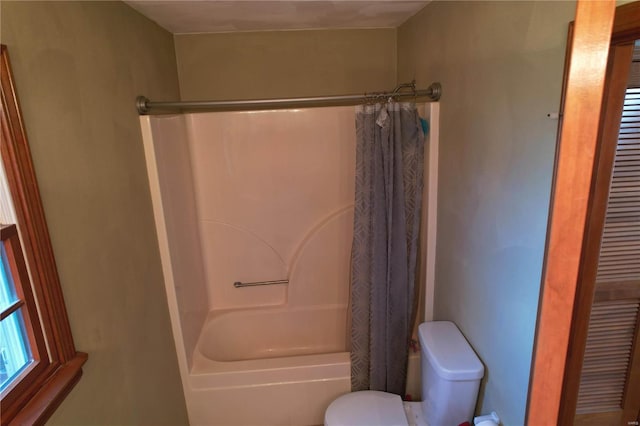 bathroom with shower / bath combo with shower curtain and toilet