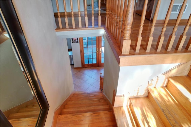 stairs with tile patterned floors and french doors