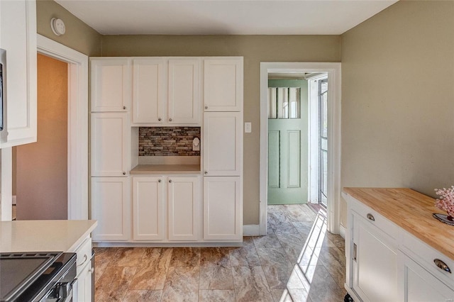 kitchen with butcher block counters, white cabinetry, stainless steel electric range oven, and tasteful backsplash