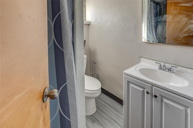 bathroom featuring hardwood / wood-style floors, vanity, and toilet