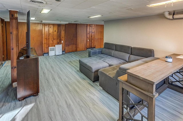 living room featuring wood walls and light hardwood / wood-style flooring