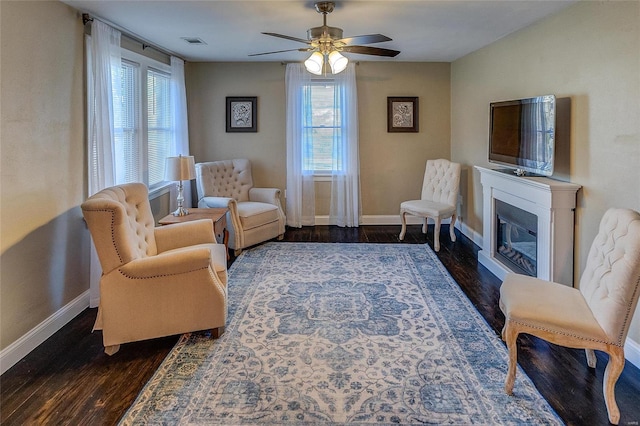 sitting room with ceiling fan, plenty of natural light, and dark hardwood / wood-style flooring