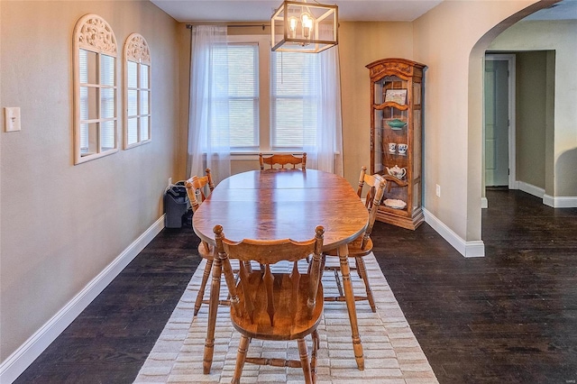 dining space featuring dark hardwood / wood-style flooring and a notable chandelier