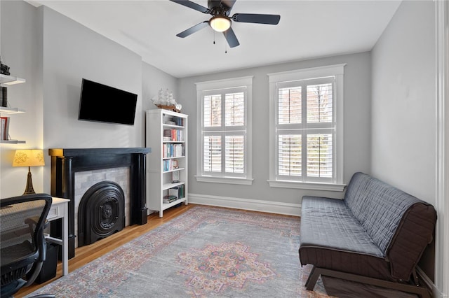 living area with hardwood / wood-style flooring and ceiling fan