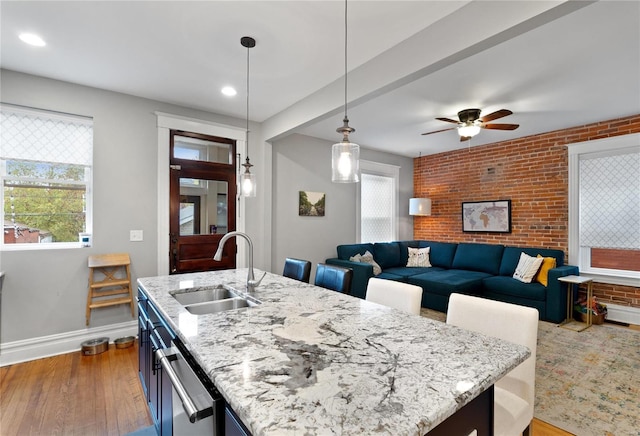 kitchen with hanging light fixtures, blue cabinets, a wealth of natural light, and sink