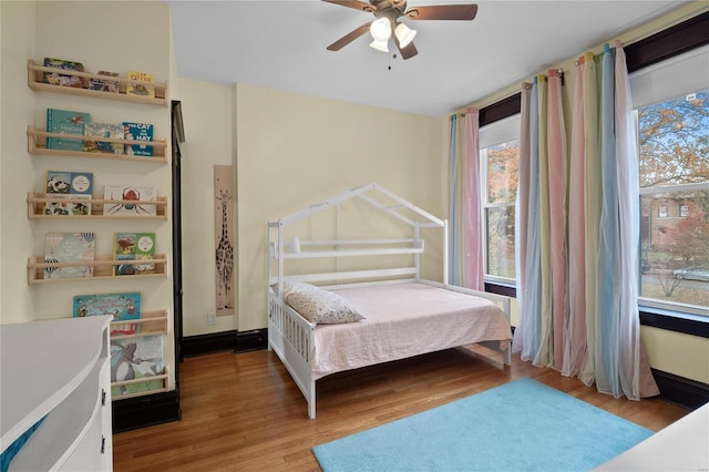 bedroom with multiple windows, ceiling fan, and light hardwood / wood-style floors