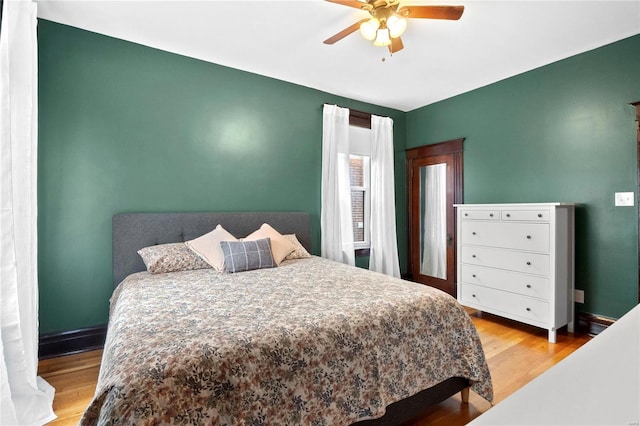 bedroom with light hardwood / wood-style floors and ceiling fan