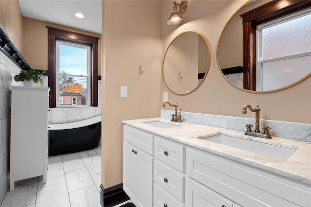 bathroom featuring a relaxing tiled tub and vanity