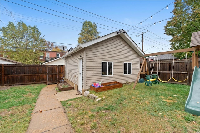 back of property featuring a lawn and a playground