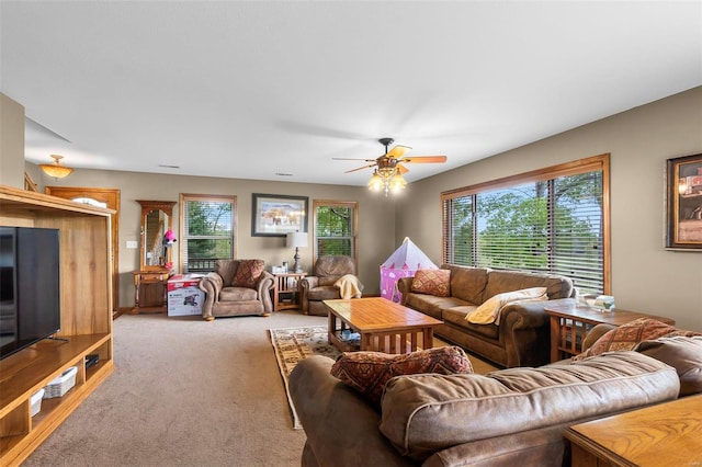 living room with ceiling fan, carpet floors, and plenty of natural light