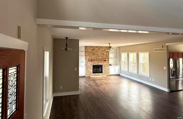 unfurnished living room with a fireplace, dark hardwood / wood-style flooring, built in features, and ceiling fan