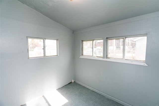 unfurnished room with lofted ceiling