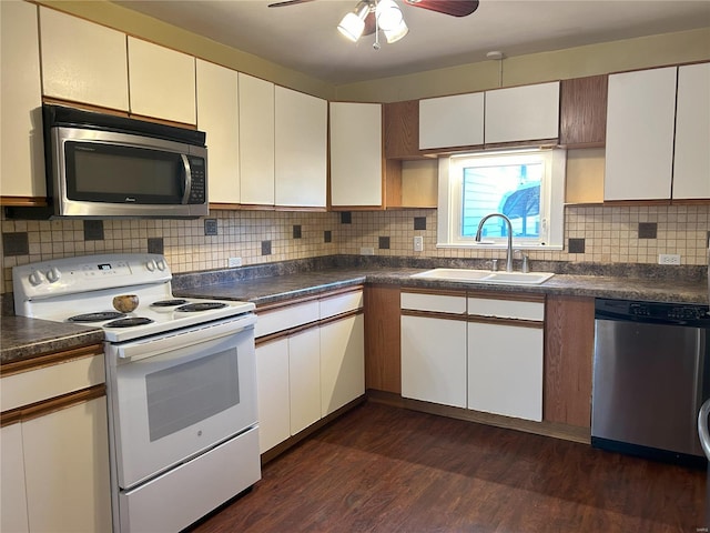 kitchen with tasteful backsplash, white cabinetry, appliances with stainless steel finishes, dark hardwood / wood-style floors, and sink