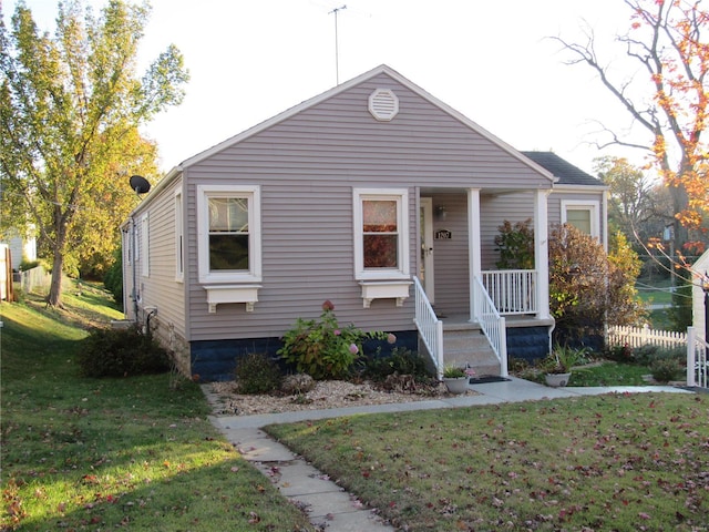 bungalow-style home featuring a front lawn and covered porch