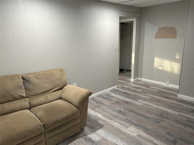 sitting room featuring wood-type flooring and wooden walls