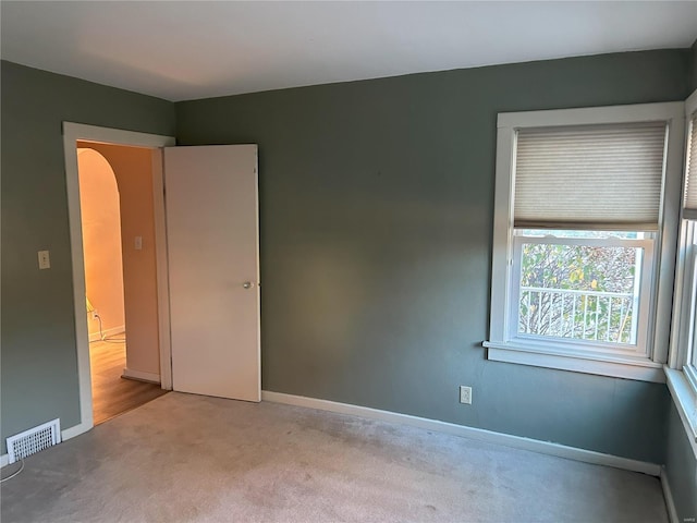 unfurnished room featuring light carpet