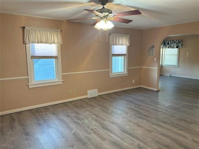 spare room featuring a wealth of natural light, wood-type flooring, and ceiling fan