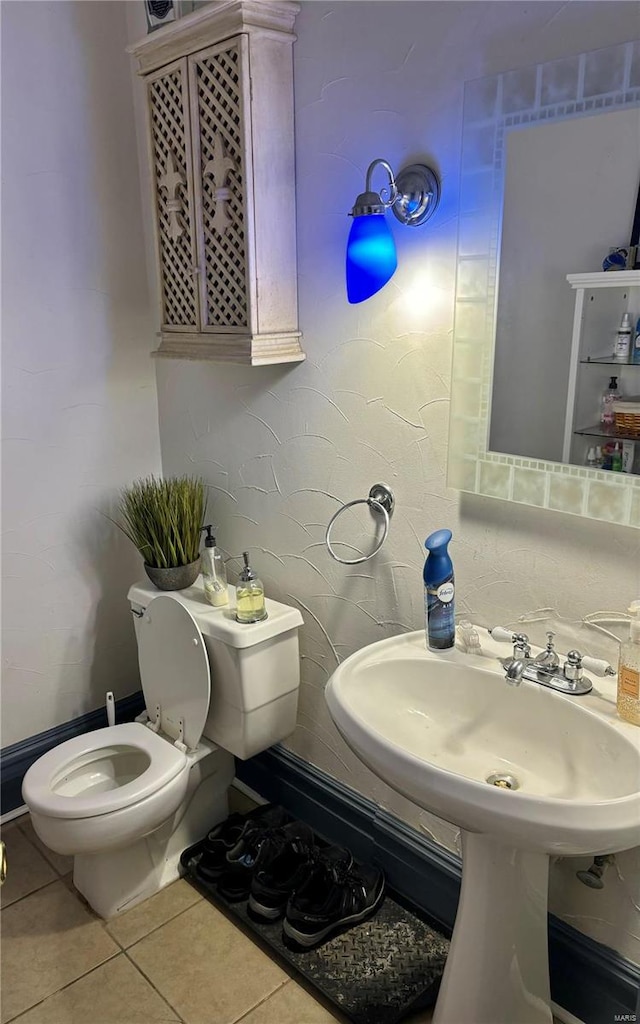 bathroom with toilet and tile patterned flooring