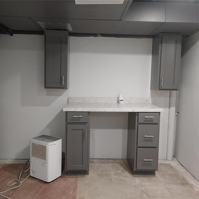 kitchen featuring electric panel and gray cabinets