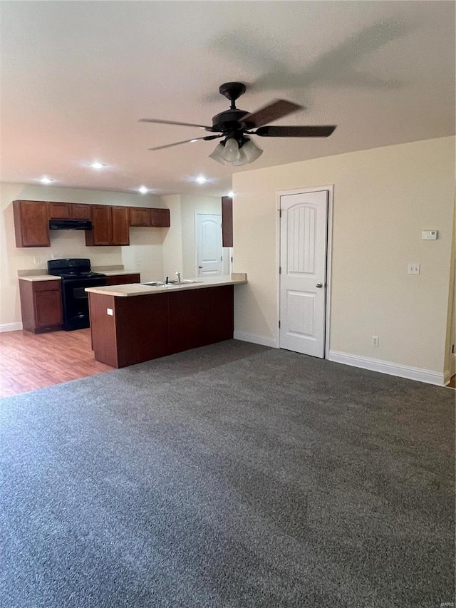 kitchen with black electric range oven, kitchen peninsula, sink, light wood-type flooring, and ceiling fan