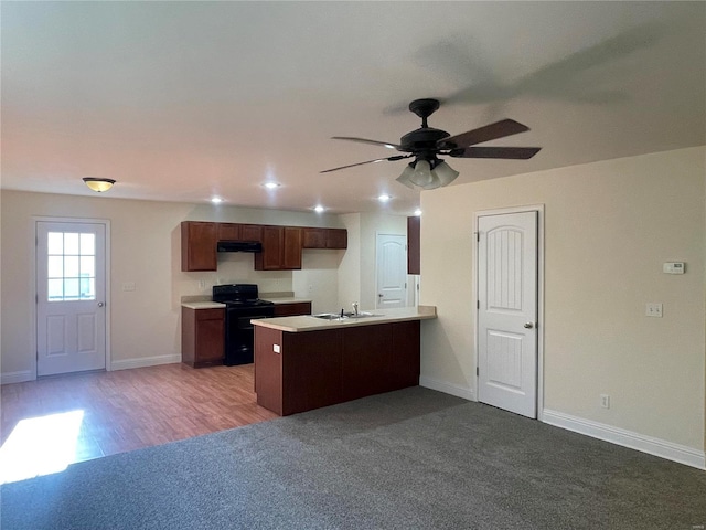 kitchen featuring sink, black range with electric stovetop, kitchen peninsula, ceiling fan, and light colored carpet