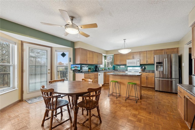 dining area with parquet flooring, a textured ceiling, and ceiling fan