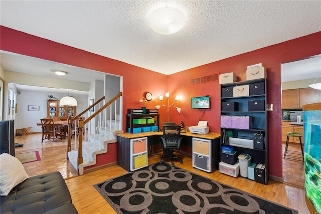 office space with a textured ceiling and light hardwood / wood-style floors