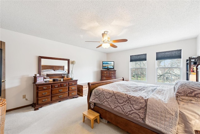 carpeted bedroom featuring ceiling fan and a textured ceiling