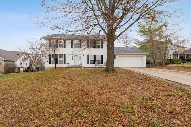 colonial inspired home featuring a garage and a front lawn